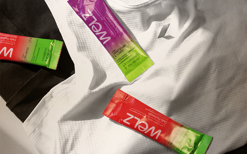 Três sachês Welz Daily Hydration sobre roupas de treino